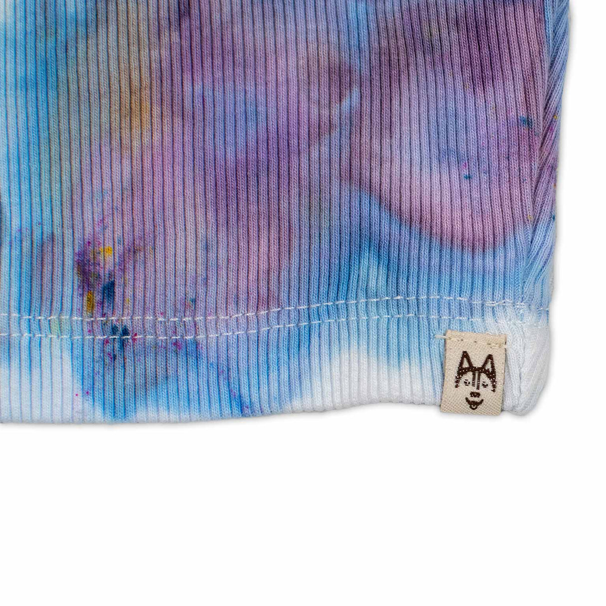 A women's high-neck cropped tank top featuring a soft ice dye pattern with swirls of blue, purple, and white on a white background, creating a dreamy, cloud-like effect.