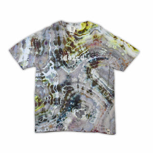 An artisanal ice-dyed t-shirt, its surface a canvas of swirling blues, purples, and chartreuse resembling geode formations, with the text 'dazed' in a stylized, icy lettering at the center.