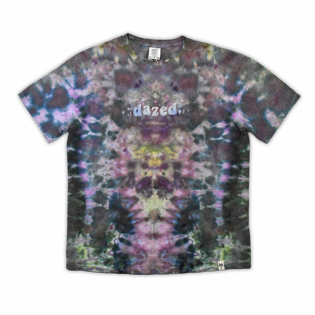 An eye-catching ice-dyed t-shirt showcasing a vibrant explosion of purples, pinks, and grays with a smoky effect around the 'dazed' text featured in the center.