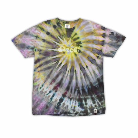 This t-shirt displays an intricate ice-dye effect that creates a starburst pattern with a mix of earthy and vibrant colors, highlighted by 'dazed' text in the middle in a style reminiscent of melting ice.