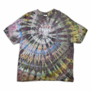 This t-shirt displays an intricate ice-dye effect that creates a starburst pattern with a mix of earthy and vibrant colors, highlighted by 'dazed' text in the middle in a style reminiscent of melting ice.