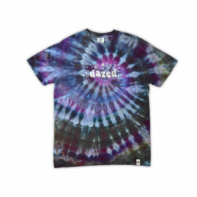 This t-shirt displays a stunning ice-dye technique creating a crystalline effect with vibrant blues, purples, and greens emanating outwards, with 'dazed' situated in the middle in a funky font.