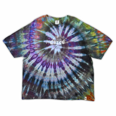 This t-shirt displays a stunning ice-dye technique creating a crystalline effect with vibrant blues, purples, and greens emanating outwards, with 'dazed' situated in the middle in a funky font.