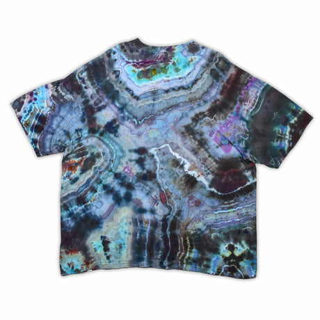 The vibrant patterns of this tie-dye t-shirt are reminiscent of a sliced geode, with bands of blue, purple, and green that encircle the 'dazed' text, which glistens like a quartz inscription.