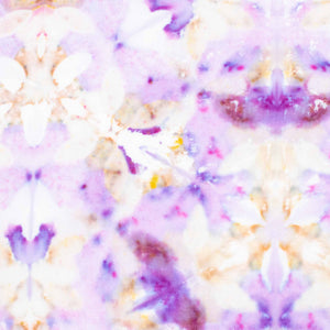 Handcrafted tie-dye bandana with a vibrant display of purple hues and white areas that symmetrically bloom into a pattern reminiscent of flowers and mandalas.