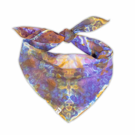 A bandana with a tie-dye design featuring symmetrical bursts of purple, orange, and yellow, creating a mirrored kaleidoscopic effect.