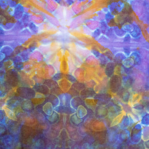 A bandana with a tie-dye design featuring symmetrical bursts of purple, orange, and yellow, creating a mirrored kaleidoscopic effect.