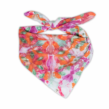 An eye-catching bandana with a tie-dye splash of neon pinks, bright oranges, and leafy greens, forming a pattern resembling a summer garden.