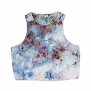 A women's high-neck cropped tank top featuring a soft ice dye pattern with swirls of blue, purple, and white on a white background, creating a dreamy, cloud-like effect. 