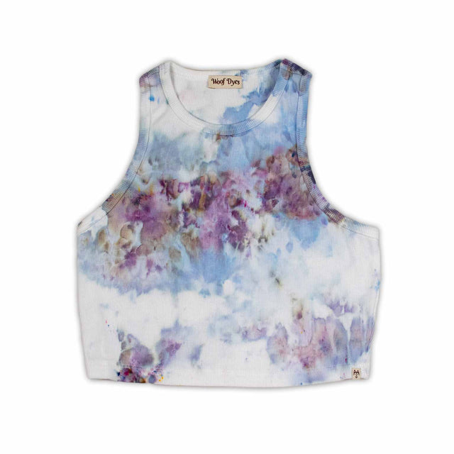 A women's high-neck cropped tank top featuring a soft ice dye pattern with swirls of blue, purple, and white on a white background, creating a dreamy, cloud-like effect. 